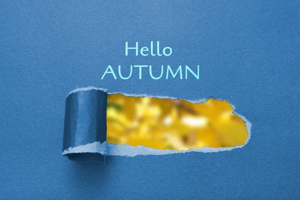 Tekst witaj jesień i niewyraźne jesienne żółte liście w rozdartym papierowym otworze — Zdjęcie stockowe