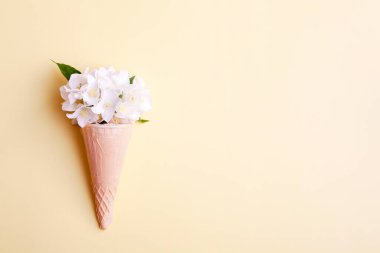 Sarı arka planda yasemin çiçekli waffle külahı. Yaz konsepti