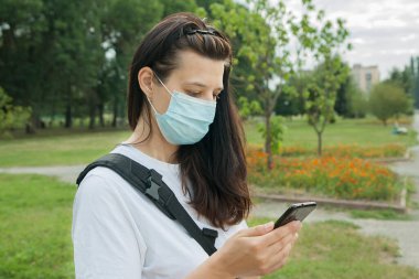 Açık havada maske takan orta yaşlı bir kadın. Yeni gerçeklik kavramı, virüs koruması.