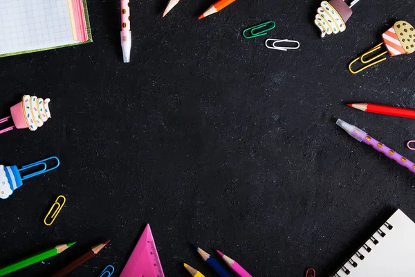Kırtasiye malzemesi siyah arkaplanda bir çerçeve oluşturdu. Kopya alanı ile okula dönüş konsepti