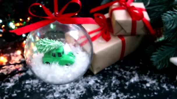 Przezroczysta Piłka Świąteczna Zabawkowym Samochodem Choinką Dachu Ciemnym Tle Kolorowymi — Wideo stockowe