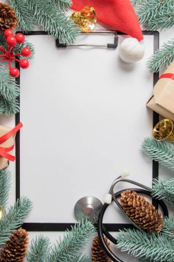 Tıbbî Noel dairesi klipsli ve steteskoplu. Yeni yıl dekoruyla çerçevelenmiş. Boşluğu kopyala