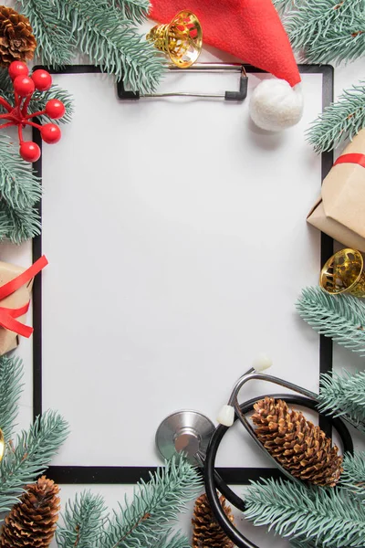 Tıbbî Noel dairesi klipsli ve steteskoplu. Yeni yıl dekoruyla çerçevelenmiş. Boşluğu kopyala