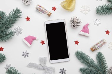 Yeni yıl dairesi telefon ile kaplandı yıldızlar, kar taneleri ve beyaz arka planda şenlikli dekorlar.