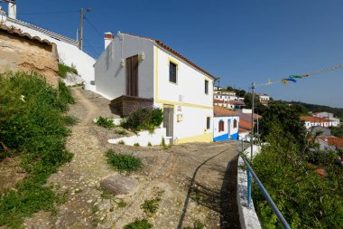 Aljezur, Portekiz - 25 Nisan 2018: Badanalı evler ve Aljezur şehrin Arnavut kaldırımlı sokakları. Aljezur bir küçük pazar Algarve, Portekiz yeridir.