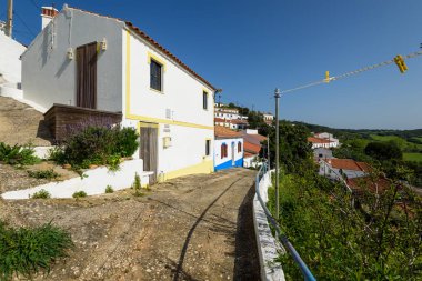 Aljezur, Portekiz - 25 Nisan 2018: Badanalı evler ve Aljezur şehrin Arnavut kaldırımlı sokakları. Aljezur bir küçük pazar Algarve, Portekiz yeridir.