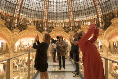 Paris, Fransa - Eylül 05, 2019: Paris 'teki Lafayette Galerisi' nin iç kesimindeki cam kaldırımındaki turistler. Mimar Georges Chedanne