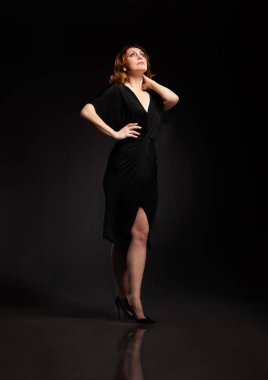 Uzun siyah elbiseli zarif bir kadının yüksek moda portresi..