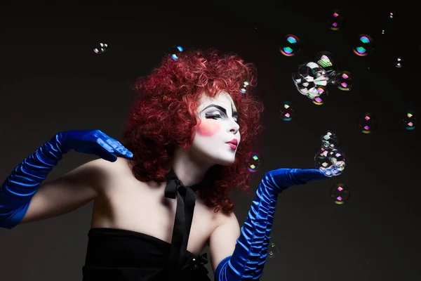 Woman mime with theatrical makeup and soap bubbles.