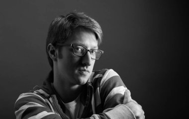 Genç adam portresi. Gri arka plana yakın yüz