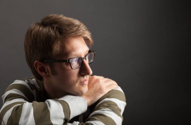 Genç adam portresi. Gri arka plana yakın yüz