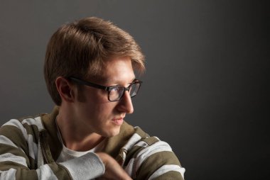 Genç adam portresi. Gri arka plana yakın yüz