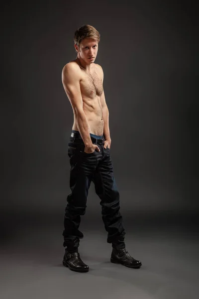 Portrait complet d'un jeune homme sexy en jeans et torse nu posant en studio . — Photo