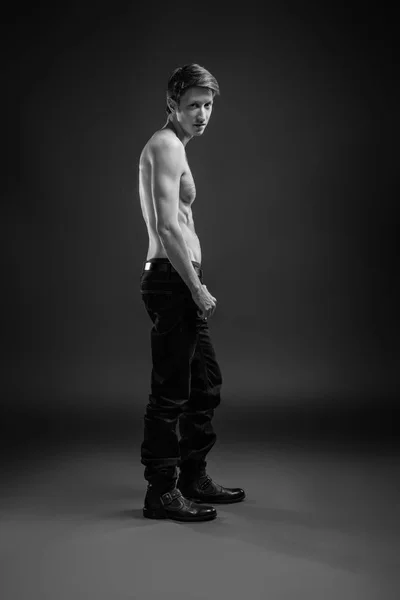 Portrait complet d'un jeune homme sexy en jeans et torse nu posant en studio . — Photo