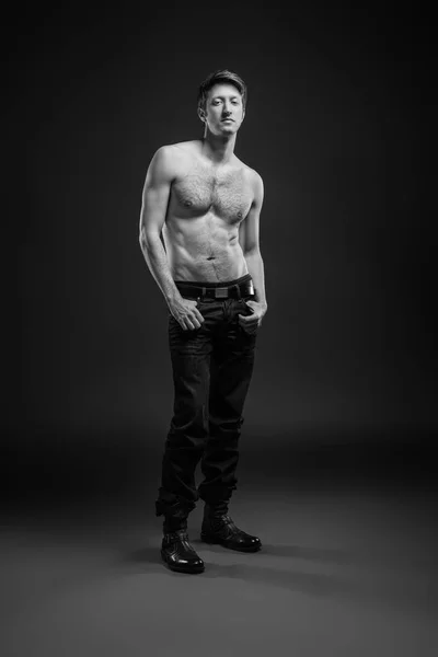 Full length portrait of a sexy young man in jeans and shirtless posing at studio. — Stock Photo, Image