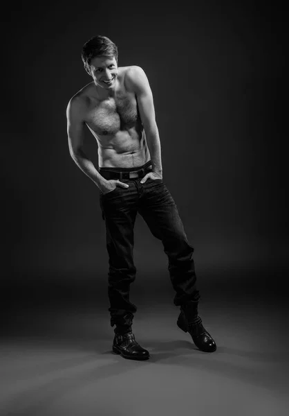Portrétní portrét sexy mladého muže v džínách a bez sebe ve studiu. — Stock fotografie
