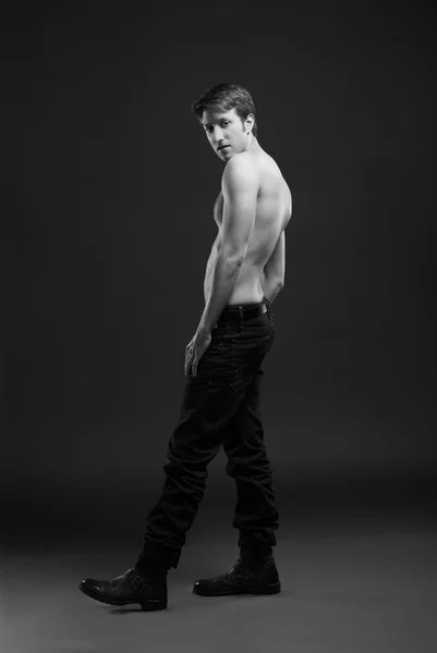 Full length portrait of a sexy young man in jeans and shirtless posing at studio. — Stock Photo, Image