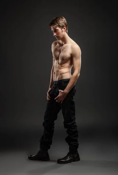 Portrait complet d'un jeune homme sexy en jeans et torse nu posant en studio . — Photo