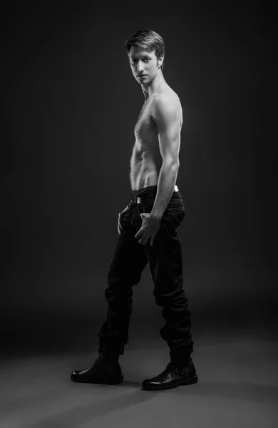 Портрет сексуального молодого чоловіка в джинсах і без сорочки позує в студії . — стокове фото