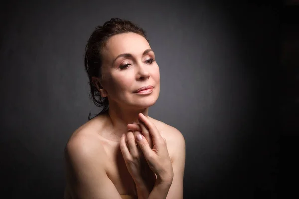 Retrato de uma sensual mulher de cinquenta anos em fundo estúdio cinza — Fotografia de Stock