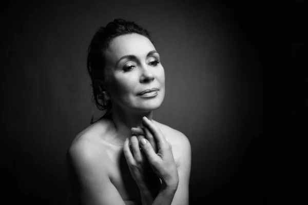 Retrato de una sensual mujer de cincuenta años sobre fondo gris del estudio. Monocromo tiro . — Foto de Stock