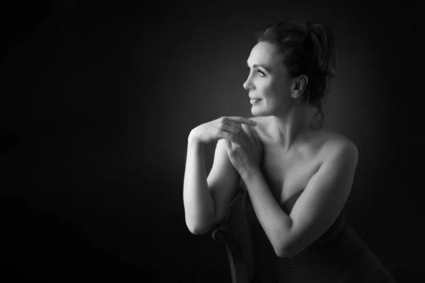 Portret van een sensuele vijftigjarige vrouw op een grijze studioachtergrond. Monochroom schot. — Stockfoto