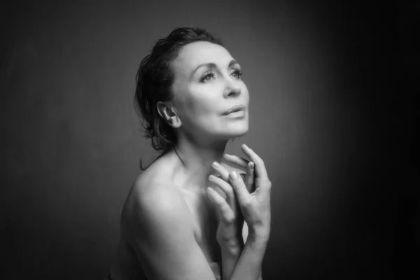 Retrato de una sensual mujer de cincuenta años sobre fondo gris del estudio. Monocromo tiro . — Foto de Stock