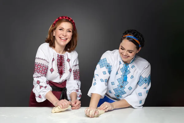 Two Adult woman in traditional ukrainian style. Cooking ukrainian varenyky. Serie. — Stock Photo, Image