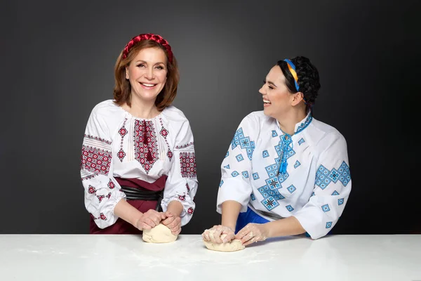 Twee volwassen vrouwen in traditionele Oekraïense stijl. Ik kook Oekraïense varenyky. Serie. — Stockfoto