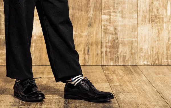 Oğlan siyah pantolon ve ayakkabı vintage ahşap zemin üzerine