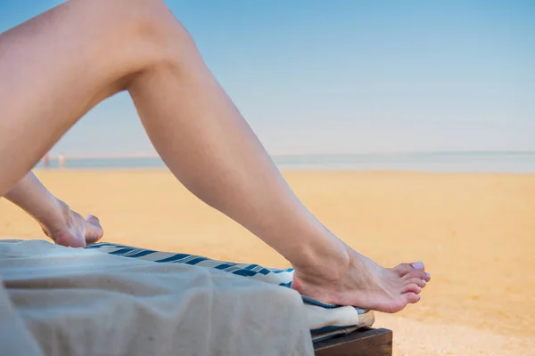 海ビーチの背景に若い女性の足 — ストック写真