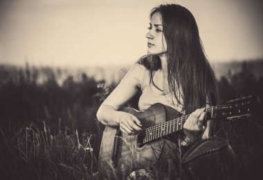 güzel kadın yüksek çayır çim eski gitar çalmak