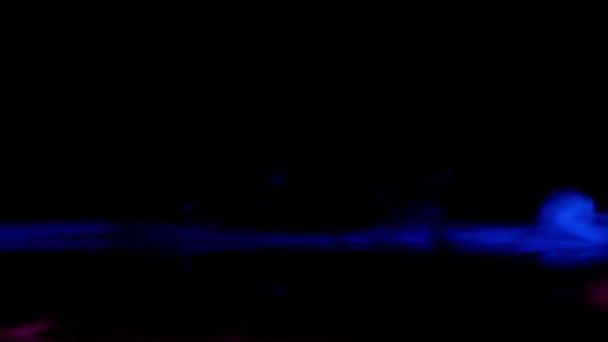 抽象红色和蓝色的烟雾条纹吹出来 并混合在黑暗的背景 — 图库视频影像