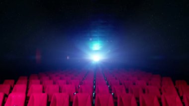 Arka planda film projektörünün ışıkları olan sinema koltukları