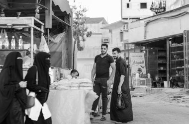 Mısır, Hurghada - 13.07.2020. Arka sokakta iki yakışıklı Mısırlı erkek, Nikab giysileri giymiş kadınlarla flört ediyor. 