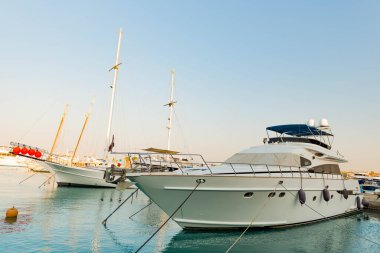 23.07.2020 - Mısır, Hurghada Marina Körfezi limanı park etmiş yatları ve yaz günbatımında deniz üzerinde yelkenli tekneleri