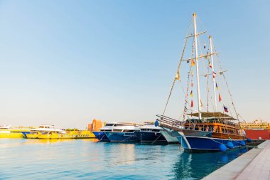 23.07.2020 - Mısır, Hurghada Marina Körfezi limanı park etmiş yatları ve yaz günbatımında deniz üzerinde yelkenli tekneleri