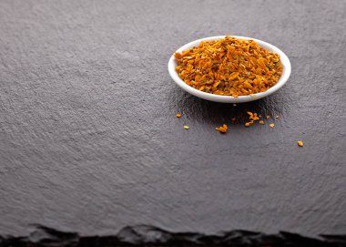 Kurutulmuş balık siyah arduvaz arka plan üzerinde beyaz bir daire için ezilmiş baharat.