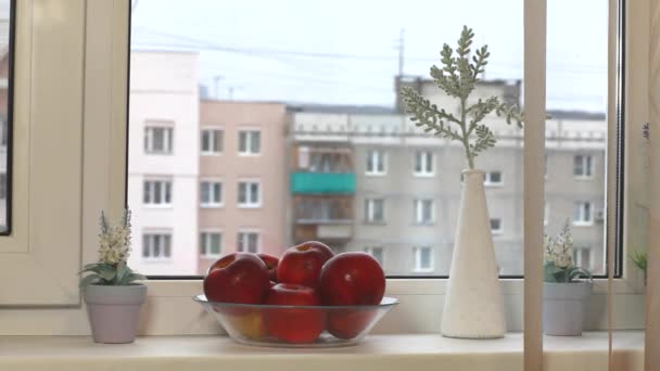 Frau Holt Einen Apfel Aus Einer Vase Fenster — Stockvideo