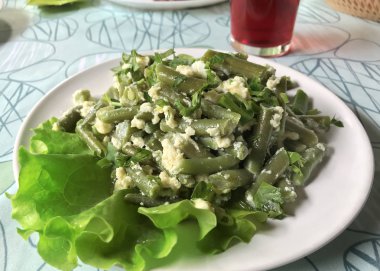 Sofra üzerinde beyaz bir plaka yumurta ile kızarmış fasulye Pod