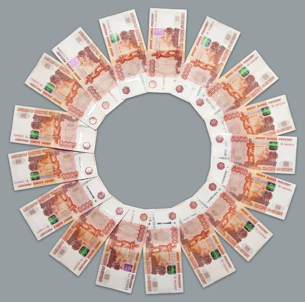 Gri arka planda yatan beş bin rublelik banknotlar halindeki Rus kağıt banknotları