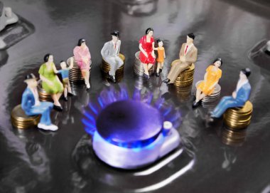İnsanlar yanan gaz brülörleri etrafında sikkeler üzerinde oturan bebek. Nüfusa doğal gaz temini.
