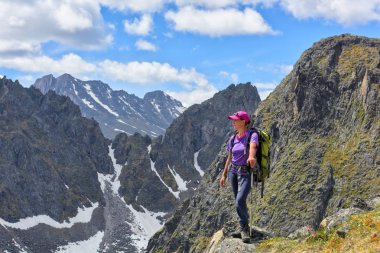Dağ doruklarına güzelliği keşfetmek turist. Bir kadın bir sırt çantası ile üst kenarında duruyor
