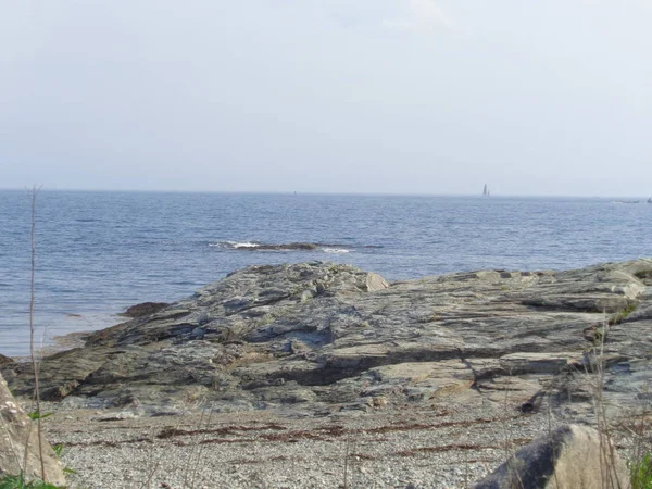 海岸で 穏やかに水から突き出た大きな岩をオフに 春の午後 — ストック写真