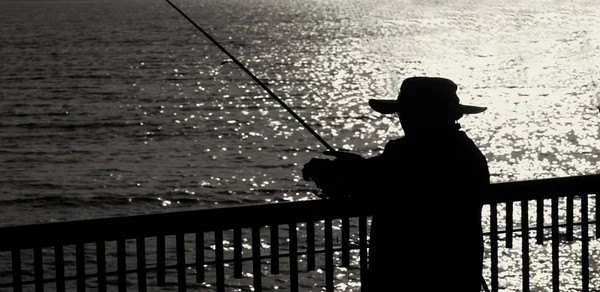 Рыбак на пирсе — стоковое фото