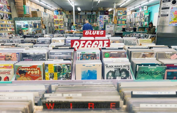 荷兰德尔福特 2018年8月25日 旧音乐唱片店内部与货架上的老式乙烯可旋转记录和客户徘徊周围 — 图库照片
