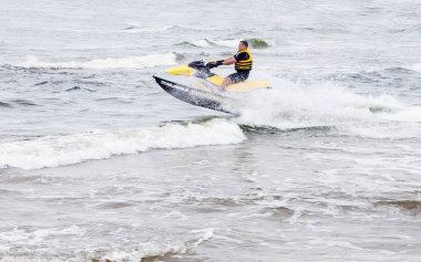 Sventoji, Litvanya - 13 Ağustos 2018: jet ski hileler dalgalar deniz yaz Baltık Denizi, Litvanya'da gerçekleştirme sürme genç adam. 