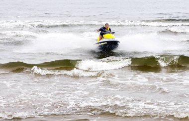 Sventoji, Litvanya - 13 Ağustos 2018: jet ski hileler dalgalar deniz yaz Baltık Denizi, Litvanya'da gerçekleştirme sürme genç adam. 