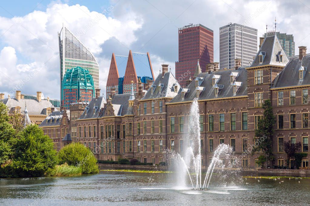 City center view of The Hague in Netherlands with pond Hofvijver and historical Binnenhof in foreground and modern skyscrapers in background