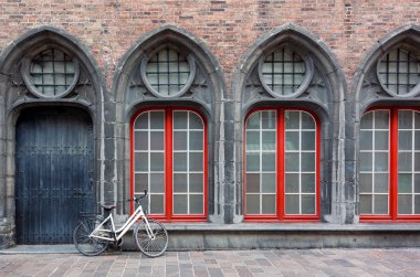 Yalnız bisiklet ayakta Bruges, Belçika'da eski tarihi bina duvara karşı